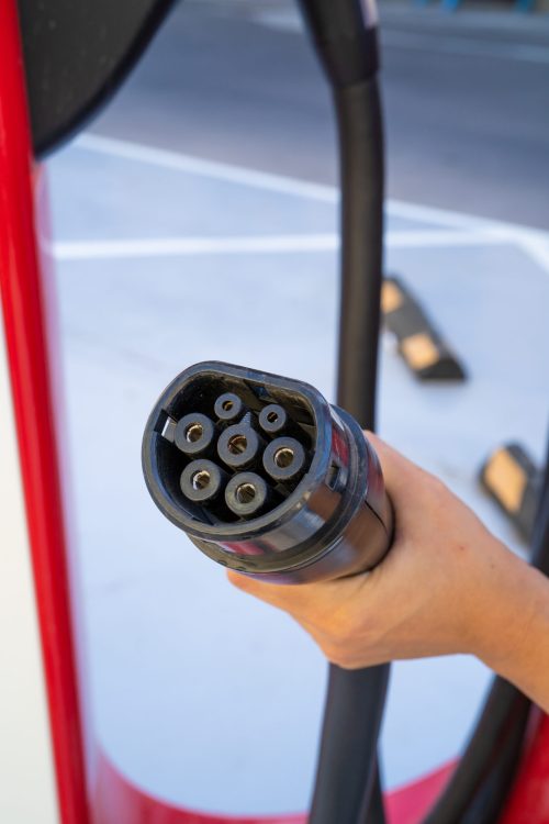 Oslo, Norway – August 20, 2019: Woman hand holding plug in conne Installer une borne de recharge en copropriété
